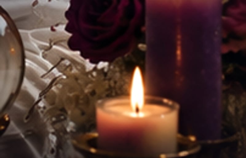 Rosa vino junto a dos velas encendidas sobre el altar